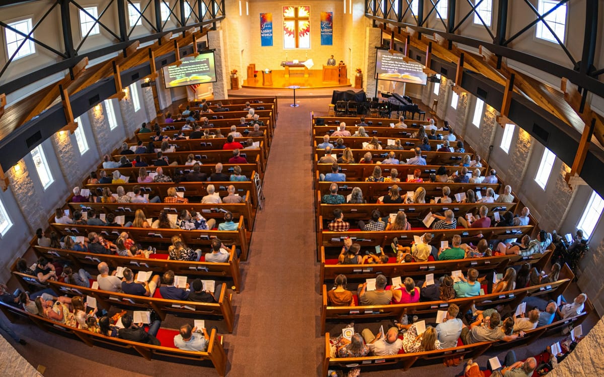 A full sanctuary seen from above, pews filled for worship